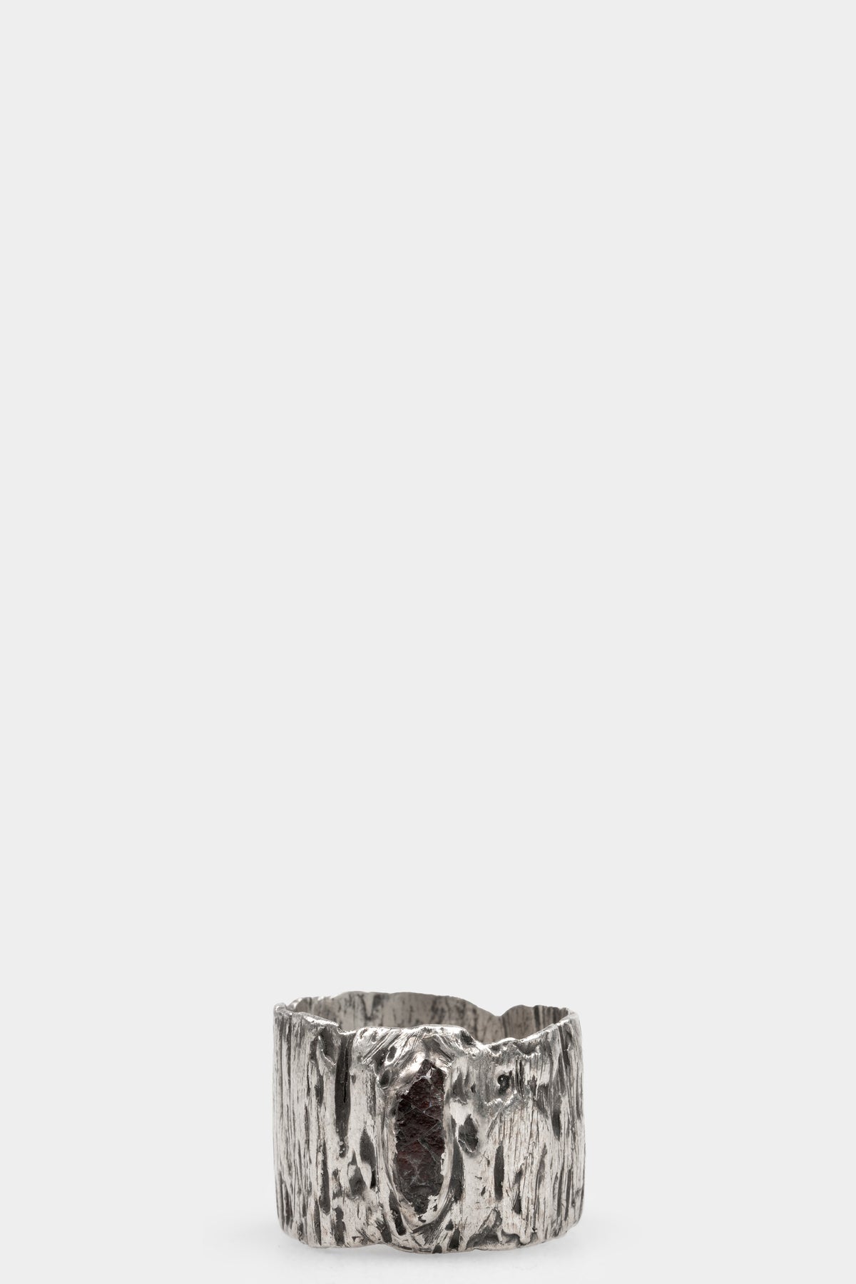 Cuma | Silver band ring with Garnet, shot on table